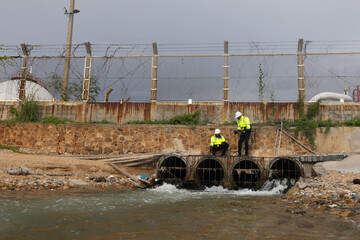 Environment engineer team with green safety jacket and PPE audit environment and quality of wastewater drain from factory 