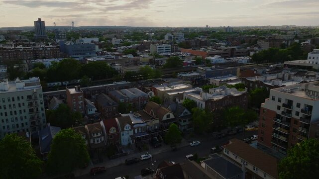 Aerial view of a residential neighborhood in Brooklyn, New York City, captured on a clear spring day. The image features mid-rise apartment buildings, tree-lined blocks, and dense housing patterns ext