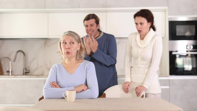 Married couple shouts at elderly mother. Family conflict between spouses and mother-in-law.