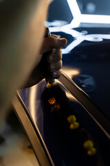 Paintless car dent repair technician uses a slide hammer on glue tabs to restore car body panels....