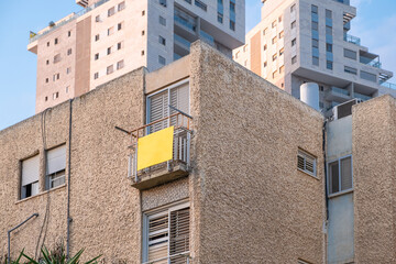 Sign on old real estate Israeli building with modern background highlights contrast in secondary housing market for sale