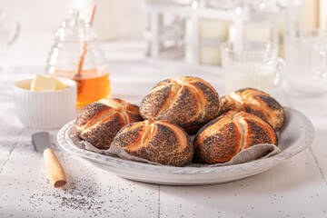 Homemade Kaiser rolls with poppy seed served with milk.