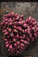 Overhead view of shallots on a brown background, top view of shallots bunch