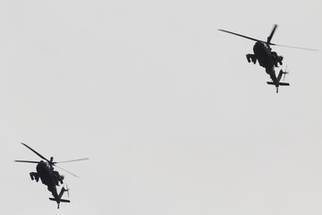 Two military choppers helicopters flying in formation. 