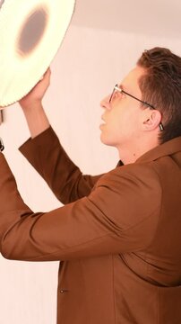 man placing beauty dish modifier on a flash