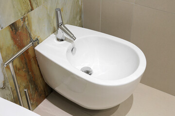 Fototapeta premium White bidet with chrome faucet close-up in the bathroom