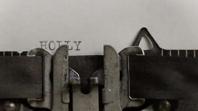 Hollywood word being typed on old vintage typewriter on white sheet of paper close-up