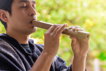 Andean man in traditional clothing playing Andean flute