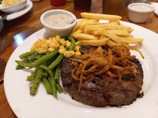 Delicious beef steak with vegetables, potatoes and onions as a complement