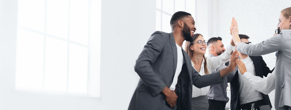 Business team giving group high five, celebrating successful project, copy space - Powered by Adobe