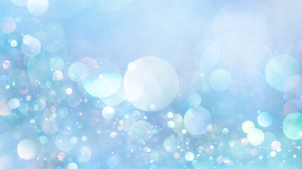 Sparkling glitter in soft, light blue colors. Dreamy shimmering particles glowing softly in a blurry bokeh of white and blue lights. Dreamlike blurred abstract background of soft pastel colors.