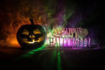 Halloween concept. Creepy silhouette in the dark corridor with pumpkin head. Toned light with fog...
