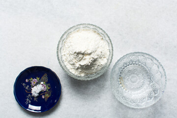 Overhead view of ingredients for making dumpling wrappers on a granite countertop, mise en place of ingredients for making wonton skins dough, process of making homemade dumplings