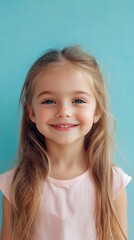 Fototapeta premium A joyful young girl with long hair and a bright smile stands against a calming blue background, radiating innocence and happiness.