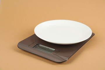 Electronic kitchen scale with empty plate on beige background, closeup