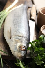 Tasty herring with spices on wooden table, closeup