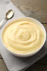 Tasty vanilla pudding served on wooden table, closeup