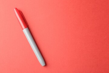 One color marker on red background, top view. Space for text