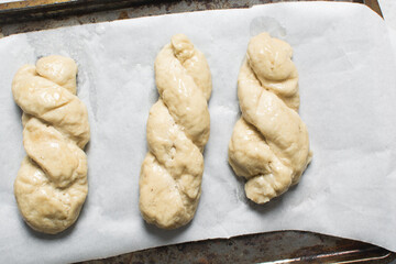 Overhead view of homemade pretzels dough on a baking tray, top view of freshly boiled soft pretzel dough on a white background