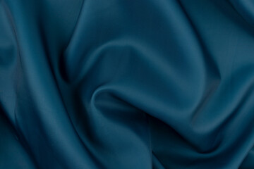 A close-up view of a dark blue cloth with textured fabric and subtle folds