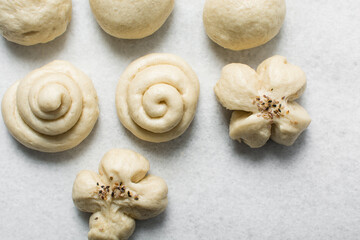 Overhead view of steamed bun on a white countertop, top view of mantou on a white background, process of making steamed milk buns