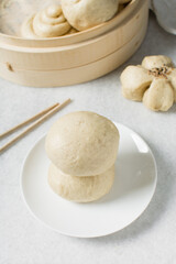 Overhead view of steamed bun on a white countertop, top view of mantou on a white background, process of making steamed milk buns