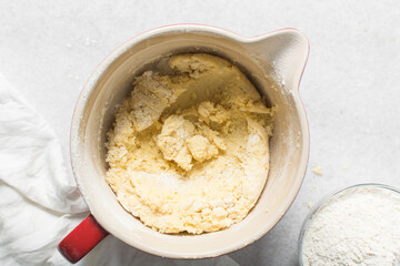 Overhead view of flour being folded into cookie dough, top view of cookie dough being mixed, process of making cookie dough