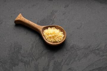 Japanese yellow panko crumbs on wooden spoon.