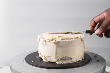 Cake being covered in buttercream frosting, Rustic cake being covered in american buttercream, process of decorating a cake