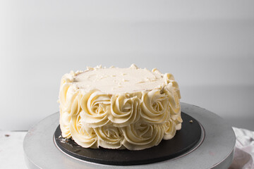Piping rosettes on a cake using buttercream, Cake being covered in buttercream rosettes, cake being...