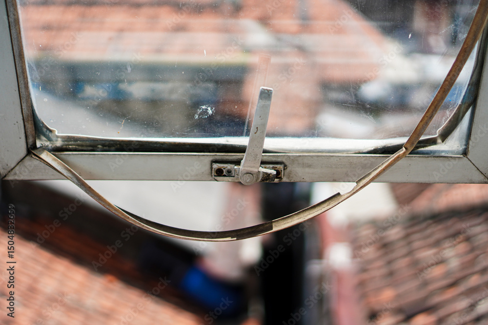 Poster an open window reflects the outside world, framing a view of rooftops and light. the design evokes a