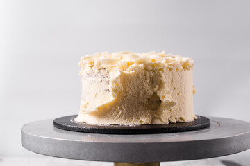 Cake being covered in buttercream frosting, Rustic cake being covered in american buttercream, process of decorating a cake