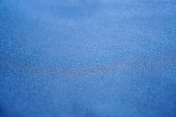 A captivating close-up presents the subtle texture of soft blue fabric, perfect for adding a...
