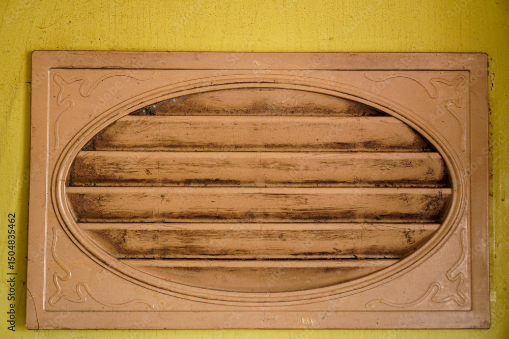 Poster close-up of an aged vent with horizontal slats set in an oval frame against a textured background. t