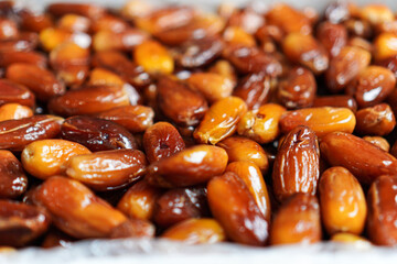 A vibrant assortment of succulent dates, their glossy surfaces reflecting light, create an inviting...