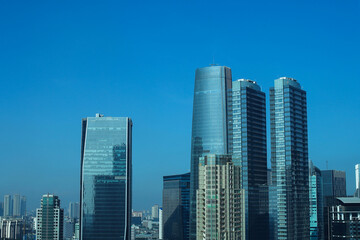 Modern City Skyline With Sleek Skyscrapers Reaching Up Against Clear Blue Sky