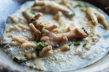 A flavorful pot of simmering chicken feet, capturing the essence of traditional cuisine. Garnished with fresh herbs, it offers a rich and savory experience, perfect for culinary enthusiasts.