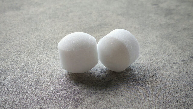 White naphthalene balls on gray background.