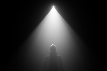 Spotlight on a solitary figure in a dark room