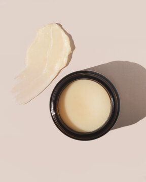 Natural and organic beef tallow balm on tan background with product texture