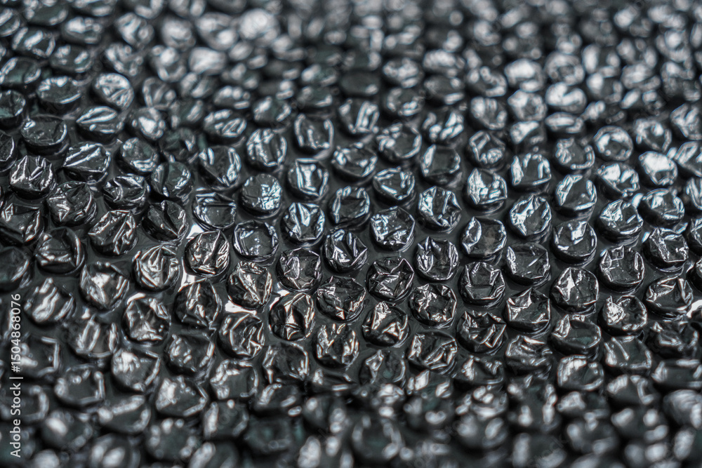 Poster a high angle close-up captures the abstract texture of black bubble wrap, creating a visually intrig