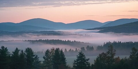 A breathtaking view of misty clouds drifting over a mountain range at sunrise
