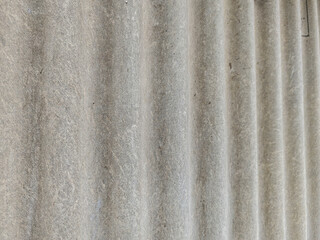 An overhead close up shows a gray, ridged roof surface, perfect for backgrounds and textures. The weathered material offers a versatile backdrop for various creative projects.