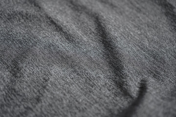 A close-up showcases the intricate texture of a tightly woven, grey fabric, subtly creased. The...