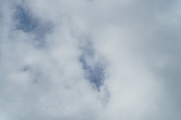 An overcast sky filled with dense clouds, creating a soft and diffused light. The clouds are...