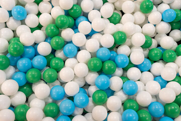 Colored plastic balls (white, green and blue) for a child game at indoor playground