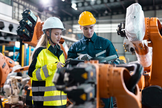 Robotic engineer team automatic checking Plan system of automation robot arms machine in factory. Programming machinery welding robots in production at factory industry.