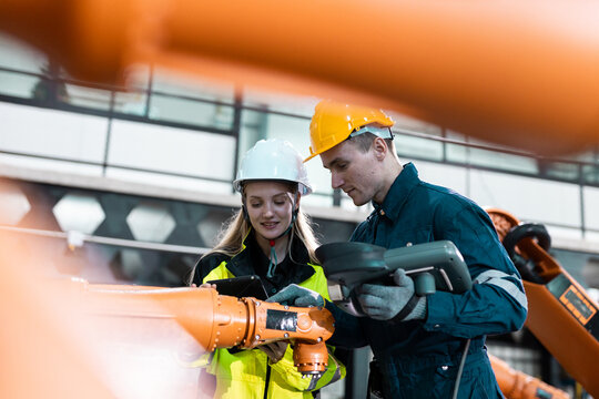 Robotic engineer team automatic checking Plan system of automation robot arms machine in factory. Programming machinery welding robots in production at factory industry..