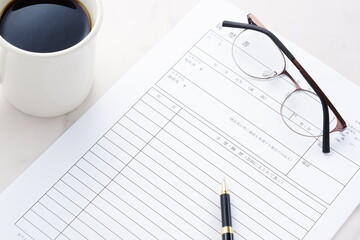 就職活動（就活）のために、コーヒーを飲みながら、履歴書を作成する
