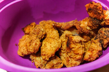 A close-up shows a bowl of golden-brown fried chicken, crispy and tempting. This hearty comfort food is perfect for parties, picnics, or casual dinners, offering a tasty experience.